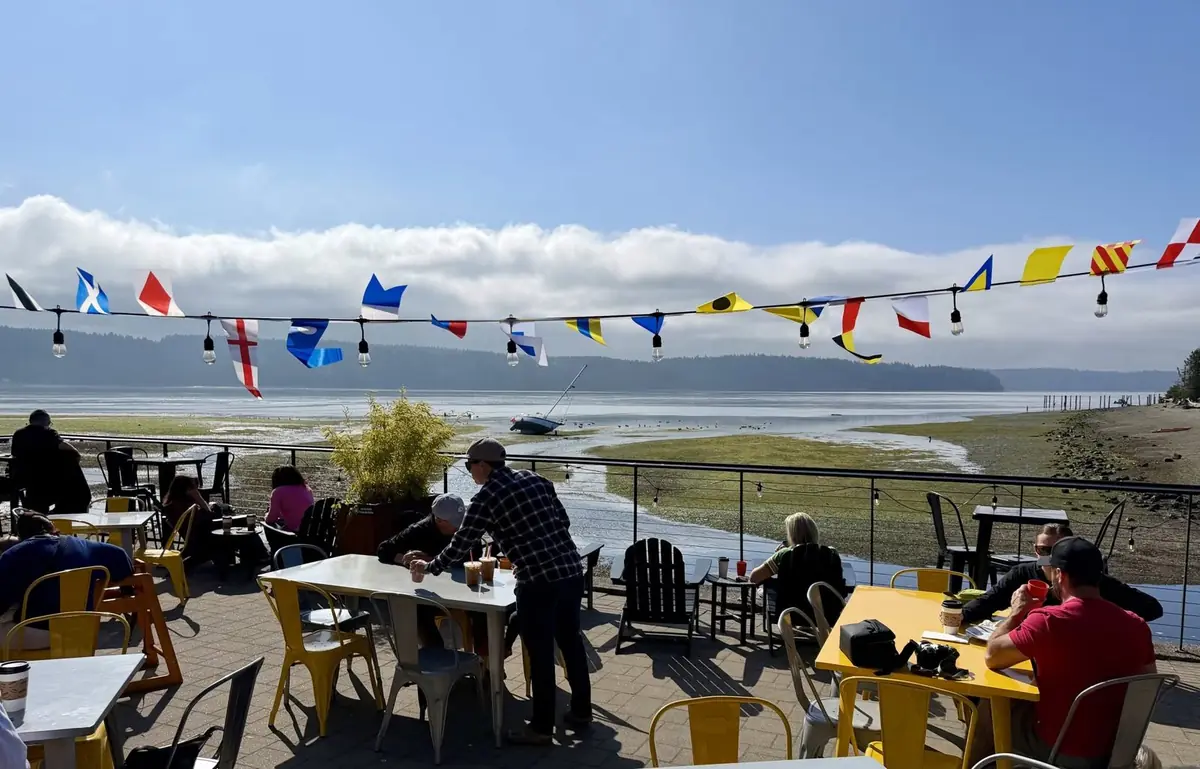 The patio at low tide, signal flags strung overhead and a sailboat resting on the mudflat